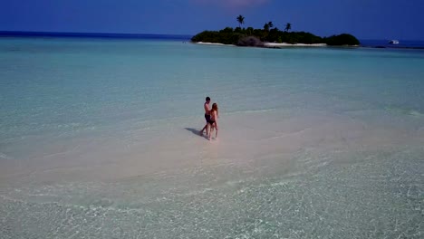 v03882-vuelo-drone-vista-aérea-de-Maldivas-playa-2-personas-pareja-hombre-mujer-amor-romántico-en-la-isla-de-paraíso-tropical-soleado-con-cielo-azul-aqua-agua-mar-4k