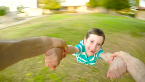 POV-footage-of-father-swinging-his-son-outdoors