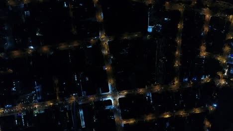 Top-View-of-Intersection,-Rooftops-and-illuminated-streets