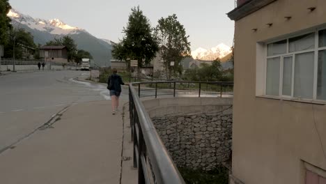 Girl-walks-through-the-evening-city-in-the-mountains---Mestia,-Georgia