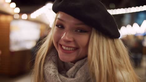 Portrait-Of-Smiling-Woman-Enjoying-Christmas-Market-At-Night