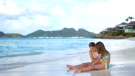 Adorables-niñas-jugando-con-la-arena-en-la-playa