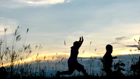 Little-boy-two-old-7-years-Happy-with-a-running-and-jump-on-meadow-in-summer-in-nature-Sunset-time.-4K-Video-Slow-motion