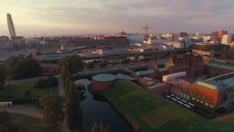 Vista-aérea-del-paisaje-urbano-de-Malmö-al-atardecer.-Tiro-de-zánganos-sobrevolando-\"Malmohus\"-en-Suecia,-Turning-Torso-en-el-fondo