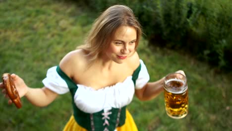 Schöne-Mädchen-auf-dem-Festival-Festival-Oktoberfest.-Die-Frau-ist-in-Bayerischer-Tracht-gekleidet,-trinkt-Bier-und-lacht-fröhlich.-Ansicht-von-oben