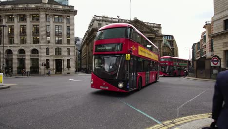 British-financial-district-with-red-double-decker-buses-and-taxis-driving-in-London,-UK.