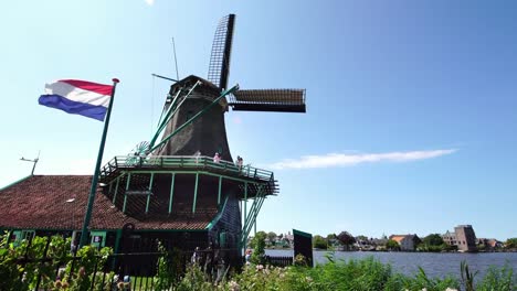 Tourist-couple-taking-pictures-of-traditional-Windmills-at-the-Zaanse-Schans-near-Amsterdam,-Holland