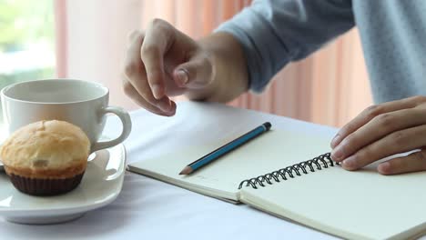 Unternehmer-oder-Student-Pferch-Buch-zu-schreiben-und-auf-Tisch-morgens-Kaffee-zu-trinken.