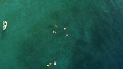 Vista-aérea-del-grupo-de-natación-con-colchón-inflable-al-lado-del-barco,-Grecia.