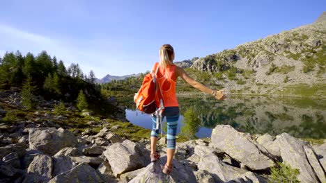 Junge-Frau-von-einer-atemberaubenden-alpinen-See-in-den-Schweizer-Alpen-Armen-weit-offen-stehen,-Natur-zu-umarmen.-Frau-Arme-ausgestreckt-Erfolg-und-Freiheit-Konzept