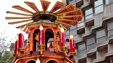 Spinning-Santa,-Xmas-Lights-Tilt---People-Enjoying-German-Christmas-Market-Stall