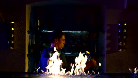 Die-professionellen-Barkeeper-cool,-erstaunlichen-tricks-mit-zwei-Flaschen-stehen-hinter-der-bar,-um-am-Ellbogen,-werfen,-Feuer-show,-Zeitlupe