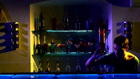 Professional-barman-making-cool,-amazing-tricks-using-bottle,-juggling-standing-behind-the-bar,-catching,-throwing-up,-and-pouring,-slow-motion