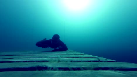 Freediver-gatear-Underwater-en-una-plataforma-de-madera