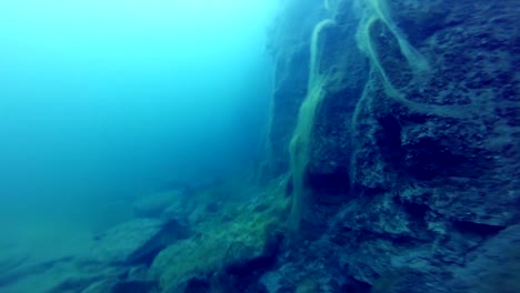 Freediver-explorar-un-lado-de-un-submarino-del-acantilado-en-una-cantera