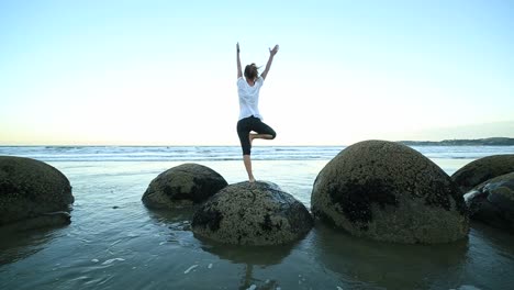 Mujer-de-ejercicios-de-Yoga-en-Boulder-en-el-mar