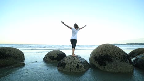 Weibliche-yoga-Übungen-auf-einem-boulder-by-die-Meer