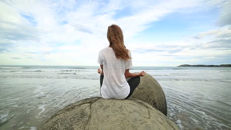 Young-female-exercises-yoga-on-the-beach