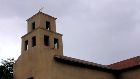 Las-nubes-de-tormenta-se-reúnen-detrás-de-una-iglesia-de-Adobe-histórico