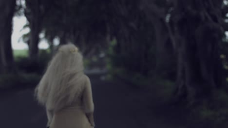 4k-Fantasy-Shot-in-Dark-Hedges,-Queen-Turning-and-Walking-Away-(close-up)