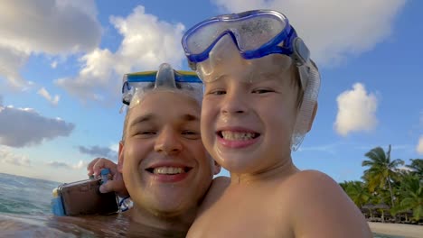 Padre-e-hijo-sonrientes-bañándose-en-el-mar