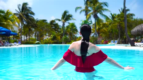 Schöne-junge-Frau-Entspannung-im-Schwimmbad.-Glückliches-Mädchen-im-Freibad-in-Luxushotel