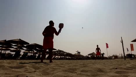 Two-men-silhouette-playing-beach-tennis-on-the-beach