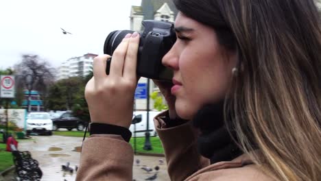 Young-Woman-photographer-taking-pictures-of-Moai-statue-at-Vina-del-Mar,-Chile