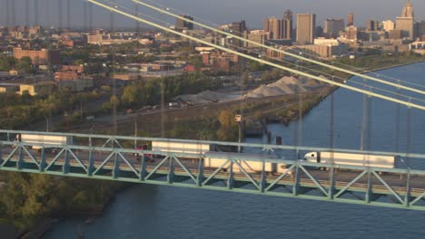 AERIAL:-Semi-trucks-crossing-the-Ambassador-Bridge-driving-goods-into-Detroit