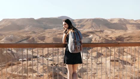 Frau-mit-Rucksack-schaut-an-massiven-Blick-auf-die-Berge.-Ziemlich-kaukasische-Mädchen-genießt-unglaubliches-Wüste-Panorama.-Israel-4K