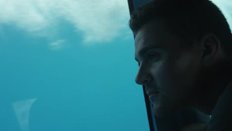 Close-up-on-a-Man-Looking-at-the-Underwater-Life-while-Being-on-the-Boat-with-the-Glass-Bottom.