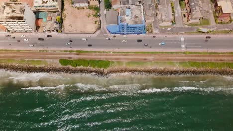 Drone-volando-sobre-la-línea-de-costa-hacia-Colombo,-Sri-Lanka.-Vista-aérea-superior-de-olas-del-mar,-calle-y-ciudad-edificios