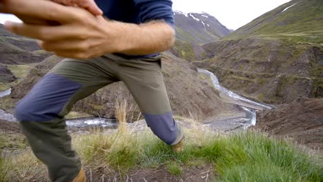 Excursionista-ayuda-a-su-compañero-de-equipo-para-llegar-a-la-cima-de-la-montaña-sobre-el-cañón-en-Islandia