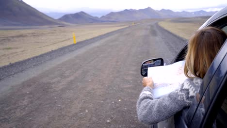 Junge-Frau-im-Auto-Blick-auf-Karte,-Road-Trip-Konzept-Urlaub---4K