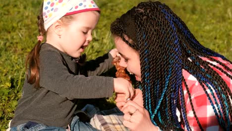 Mama-füttern-ihre-süße-kleine-Tochter-mit-Fleisch-Schaschlik-Grill-am-Spieß-im-Hinterhof.