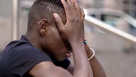 focus-on-sad-young-attractive--African-man--in-prayer---outdoor