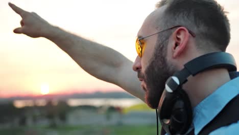 Perfil-de-moda-DJ-con-auriculares-y-gafas-de-sol-disfrutando-de-la-música-en-la-fiesta-de-verano-en-la-azotea