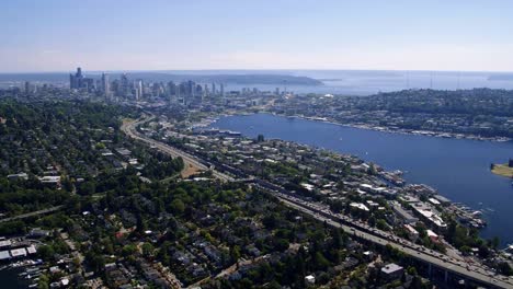 Heli-View-Over-Seattle-Waterfront-Community-with-Skyline-Background