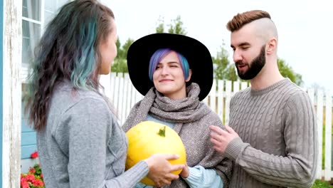 Three-people-in-background-of-village-house-on-farm-talk-and-laugh.