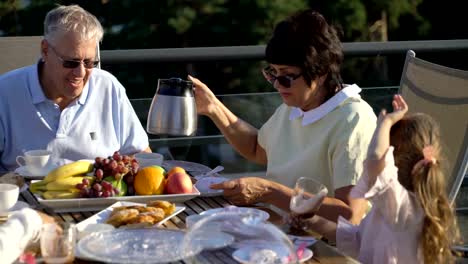 Eine-große,-glückliche-Familie-hat-Abendessen-auf-der-Terrasse-auf-dem-Dach-des-Hauses.