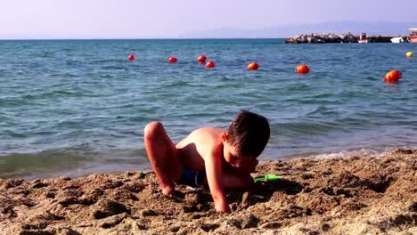 Little-boy-on-a-sea-beach,-Greece