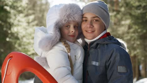 Porträt-von-entzückenden-Geschwister-im-Winterwald