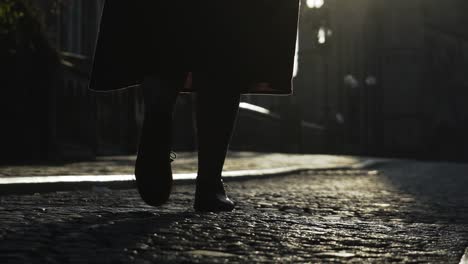 Woman-walking-on-cobblestone-pavement