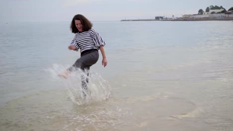 Beautiful-middle-aged-woman-jumping-in-seawaves.