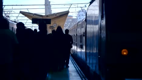 In-den-Bahnhofstüren-des-Zuges-öffnet-sich-und-ankommende-Passagiere-beginnen-zu-verlassen