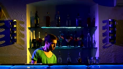 Professional-bartender-making-cool,-amazing-tricks-using-two-glasses,-shaker-and-bottle-standing-behind-the-bar,-catching-on-elbow,-throwing-up,-slow-motion