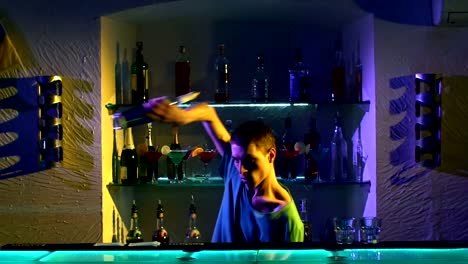 Professional-bartender-making-cool,-amazing-tricks-using-bottle-and-two-shakers-standing-behind-the-bar,-catching,-throwing-up,-slow-motion