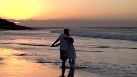 Paar-genießen-einen-romantischen-Umarmung-am-Strand-silhouette,-Südafrika