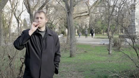 Young-guy-smokes-cigarette-at-street