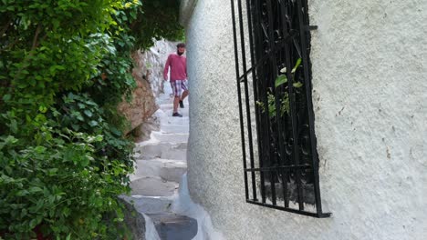 Single-man-walking-narrow-streets-of-Plaka,-Athens,-Greece